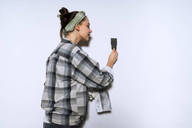 Bir genç kız ekose gömlekli duvarları yeni evinde tesviye, tamir