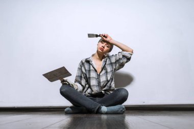 Tamirat yapmaktan yorgun onun yeni evinde katta oturan yorgun genç kız