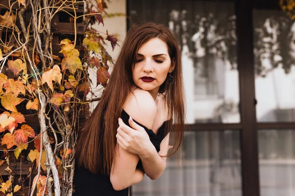 Attraktiva Sexig ung kvinna i en svart klänning poserar, promenader genom trädgården, njuta av ett rikt och lyxiga liv — Stockfoto