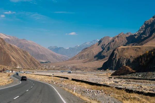 Magestic high mountains under the blue sky, highways and cars — стоковое фото