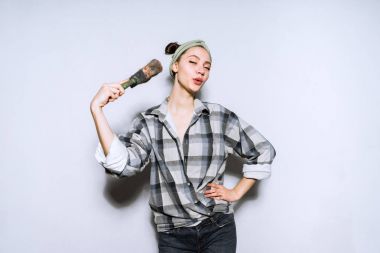 mutlu genç kız boyama duvarları için boya fırçası tutan büyük Kareli gömlekli