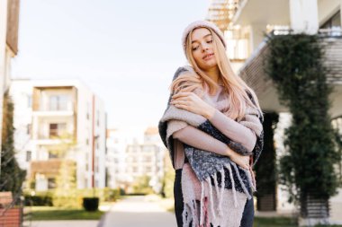 şehrin sokaklarında yürürken şapkalı sevimli genç sarışın kız bahar havanın tadını