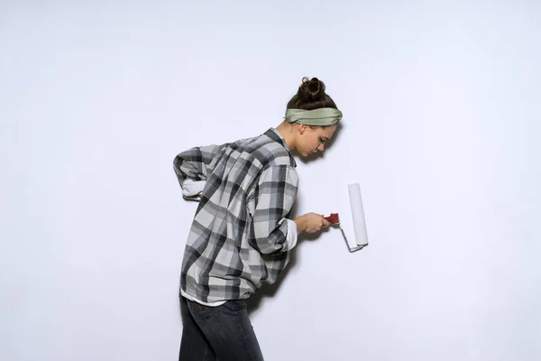 Ijverig meisje in een plaid shirt nivelleren van de muren met een spatel — Stockfoto