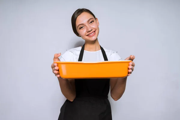 Щаслива молода жінка готує в чорному фартусі приготовану смачну їжу в духовці — стокове фото