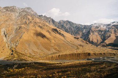 Sihirli doğa, yüksek dağlar ve yamaçlarında kar, sarı tepeler ile kaplı