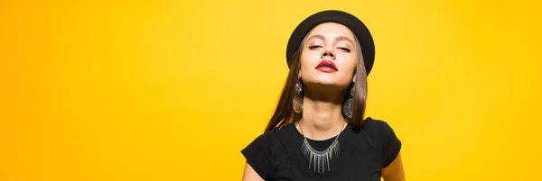 Aantrekkelijke luxe jong meisje in een zwarte hoed poseren, in de oren dure oorbellen — Stockfoto