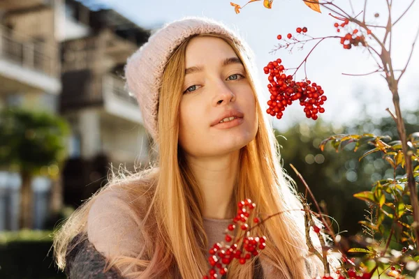 Vacker ung blond flicka med blå ögon går genom trädgården, iklädd en rosa hatt, njuta av naturen — Stockfoto