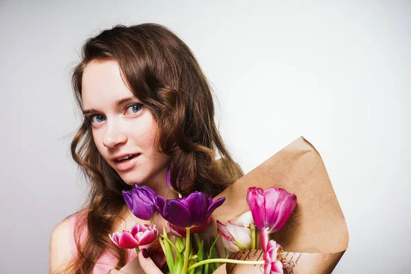 Hermosa chica atractiva sosteniendo un gran ramo de flores fragantes, celebrando el día mundial de la mujer, 8 de marzo —  Fotos de Stock