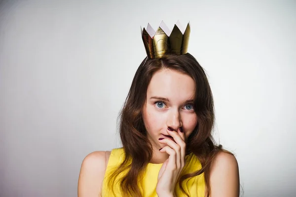 Feliz hermosa chica de ojos azules celebra el día de la mujer del mundo, en su cabeza una corona de oro, esperando regalos — Foto de Stock