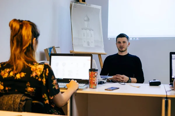 Giovane uomo e donna che lavorano in ufficio insieme su un progetto, grafici — Foto Stock