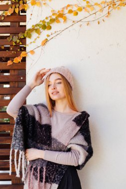 genç kız sarışın model beyaz bir duvar karşı açık havada, sonbahar hava poz pembe şapkalı gülümseyen