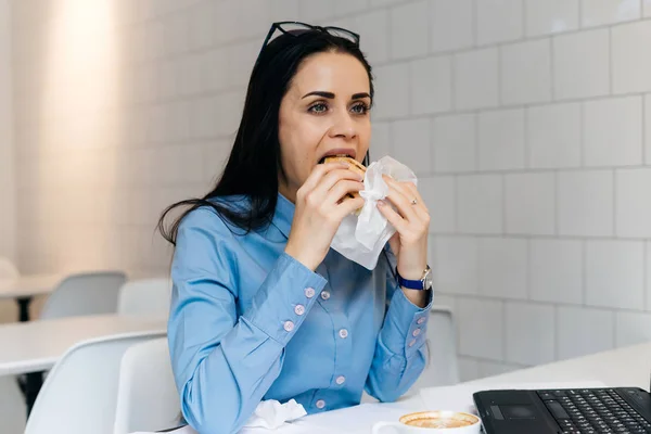 青いシャツを着てカフェで昼食を空腹少女学生 — ストック写真