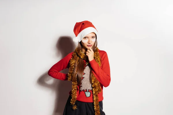 Menina bonita pensativa em roupas de Ano Novo vermelho pensa em algo, sob os olhos manchas brancas — Fotografia de Stock