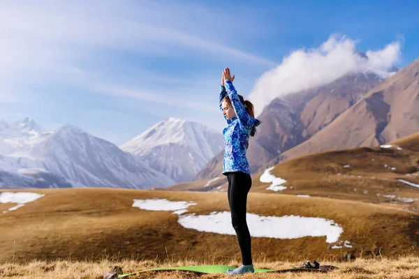 Женщина-турист, практикующая йогу на фоне гор — стоковое фото