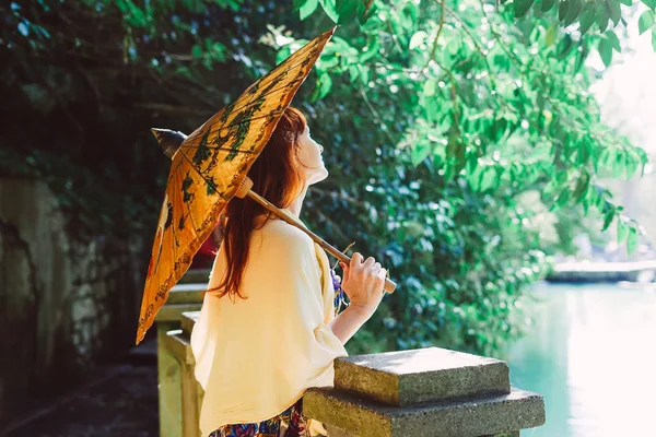 Woman holding an umbrella in hands on a lake background — Stock Photo, Image