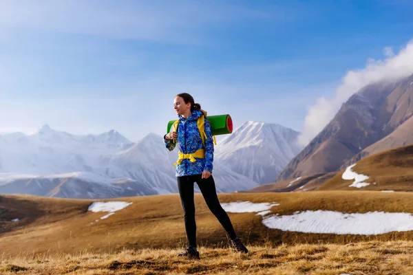 Kadın turist arka planda dağların büyük bir sırt çantası ile — Stok fotoğraf