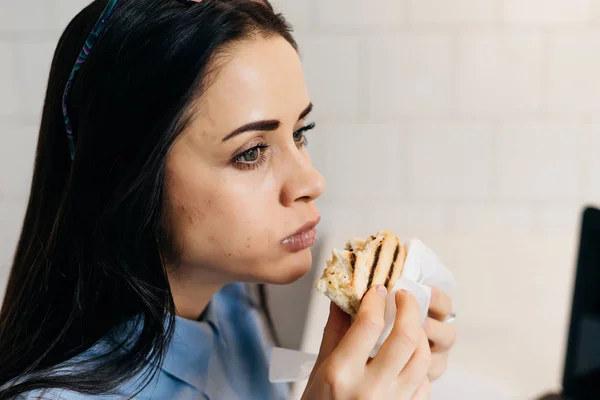 사무실에서 샌드위치를 먹는 여자 — 스톡 사진