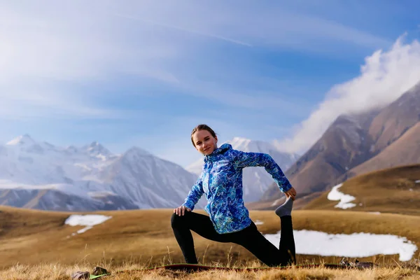 Жінка на тлі гір виконує вправи — стокове фото