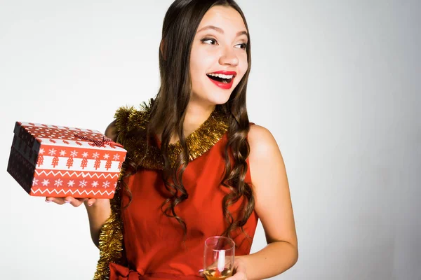 Vrouw op een gele witte achtergrond houdt een Nieuwjaars-gift — Stockfoto