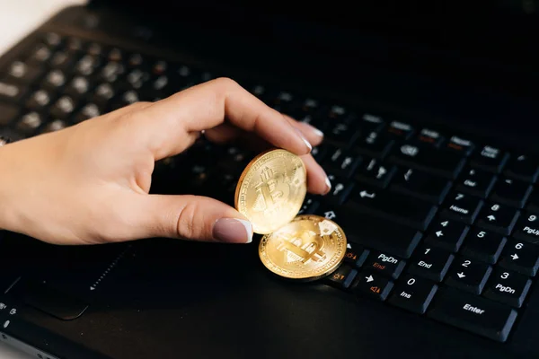 Mujer sostiene una moneda criptográfica en un fondo portátil — Foto de Stock