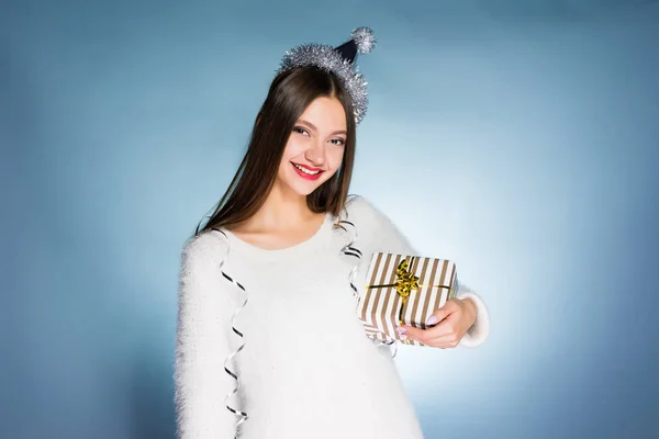 Mulher em um fundo azul está feliz com seu presente de Ano Novo — Fotografia de Stock