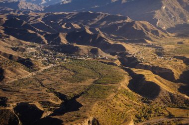 yüksek yeşil dağların arka planda küçük bir şehir