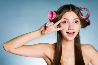 kadın curlers eğleniyor mavi arka plan üzerinde