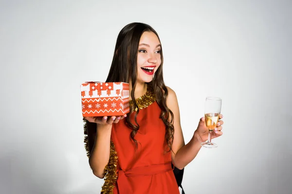 Счастливая женщина с бокалом шампанского и подарком в руке — стоковое фото