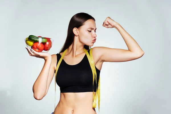 Sportovkyně v černý top drží zeleniny v ruce — Stock fotografie