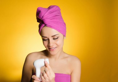 kadının kafasındaki bir havlu ile derin temizleme için bir fırça tutar