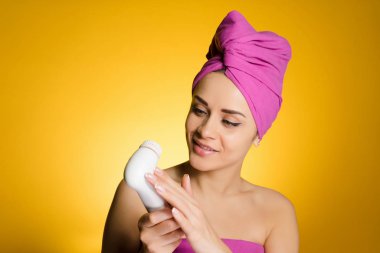 derin temizleme için bir fırça tutan başında bir havlu ile mutlu kadın