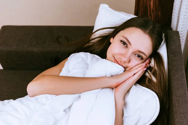 Boldog nő fekszik az ágyon, a takaró alatt — Stock Fotó