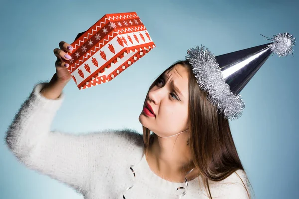 Sorgliga kvinna i en festlig hatt håller en tom ruta från under gåvan — Stockfoto