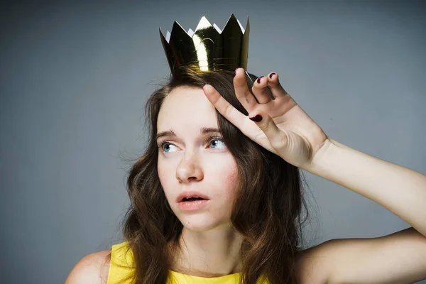 Jovem triste em um vestido à espera de um dia mundial das mulheres, em sua cabeça uma coroa de ouro — Fotografia de Stock