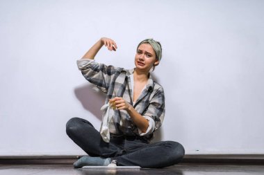 katta oturan memnun üzgün genç kızın elinden lastik eldiven kaldırır