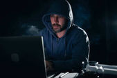 muž s kapucí na hlavě, trestní hacky notebook ve tmě