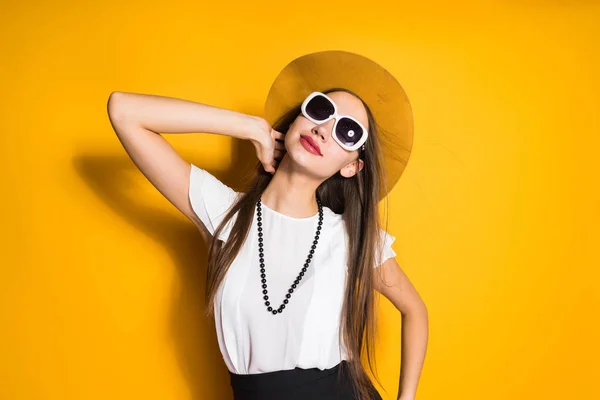 Modelo de chica atractiva y elegante en sombrero y gafas de sol negras posando, en blusa blanca — Foto de Stock