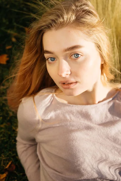 Joven de ojos azules chica rubia modelo se encuentra en el campo, disfruta del sol y la calidez — Foto de Stock