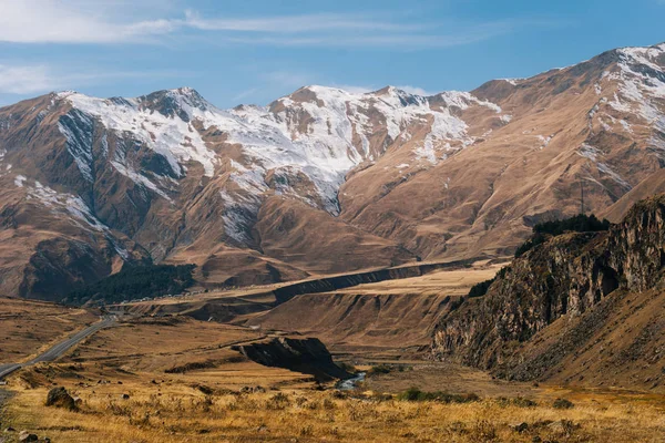 Inspiring magic nature, the Caucasus mountains are covered with white snow, endless yellow fields — Stock Photo, Image