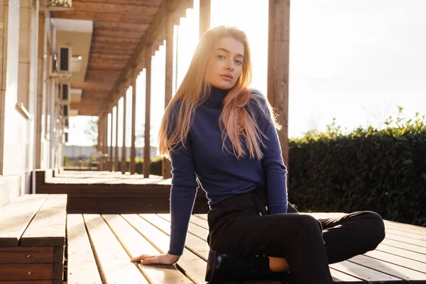 Menina modelo loira bonita elegante em suéter azul posando ao ar livre, apreciando o clima quente da primavera — Fotografia de Stock
