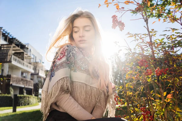 Bela menina loira de cabelos longos caminha pelo parque, desfrutando de um dia quente de primavera, muitas plantas e árvores — Fotografia de Stock