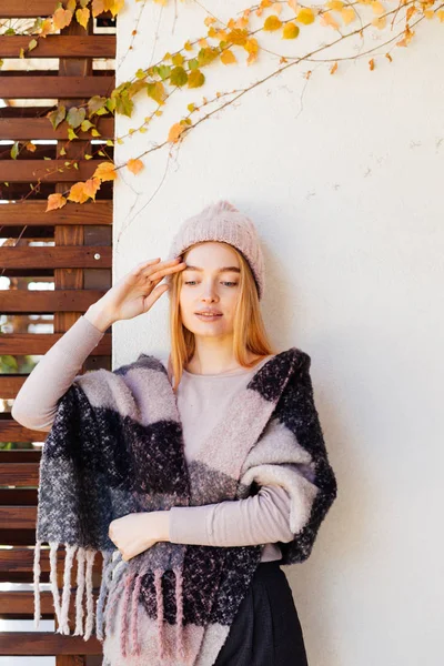 Vacker ung blond flicka i en rosa hatt, på hennes axlar varm ull halsduk, promenader i parken — Stockfoto