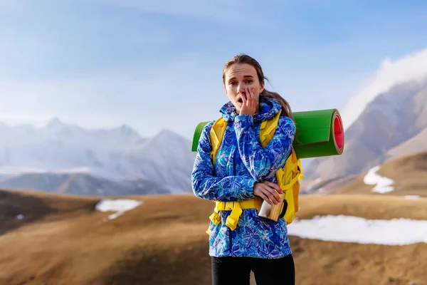 Młoda dziewczyna zaskoczeni w Błękitnej Kurtki przemieszcza się przez góry Kaukazu z plecakiem — Zdjęcie stockowe