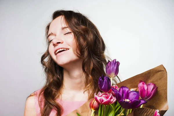 Gelukkig lachend meisje houdt van een groot boeket van geurige bloemen, vieren dag van de vrouw van de wereld — Stockfoto