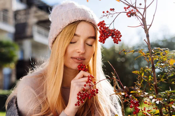 Gelukkig jong blond meisje in een roze hoed wandelen in de tuin, genieten van de natuur en de zon — Stockfoto