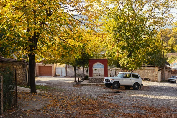 Un pequeño pueblo al pie de las montañas, muchos árboles verdes en el sol —  Fotos de Stock