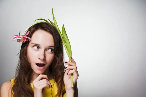 Linda chica sorprendida joven sosteniendo flor rosa, celebrando el día de la madre — Foto de Stock