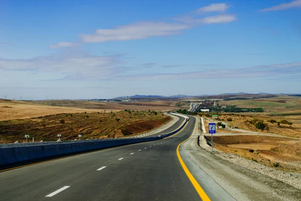 Endless road, highway, yellow fields and meadows under the blue sky — Stock Photo, Image