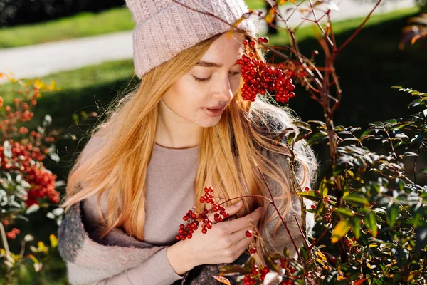 Piękna młoda dziewczyna z blond włosami, chodzenie w różowy kapelusz w ogrodzie, zachwyt przyrodą i dzień wiosny — Zdjęcie stockowe