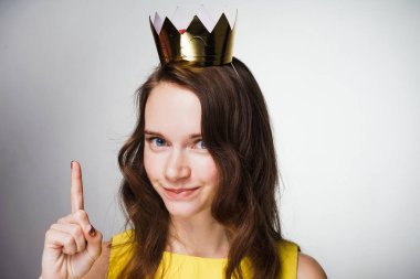 Sarı elbiseli güzel genç kız parmağını kaldırdı, bir fikir başına, altın bir taç ortaya çıktı.